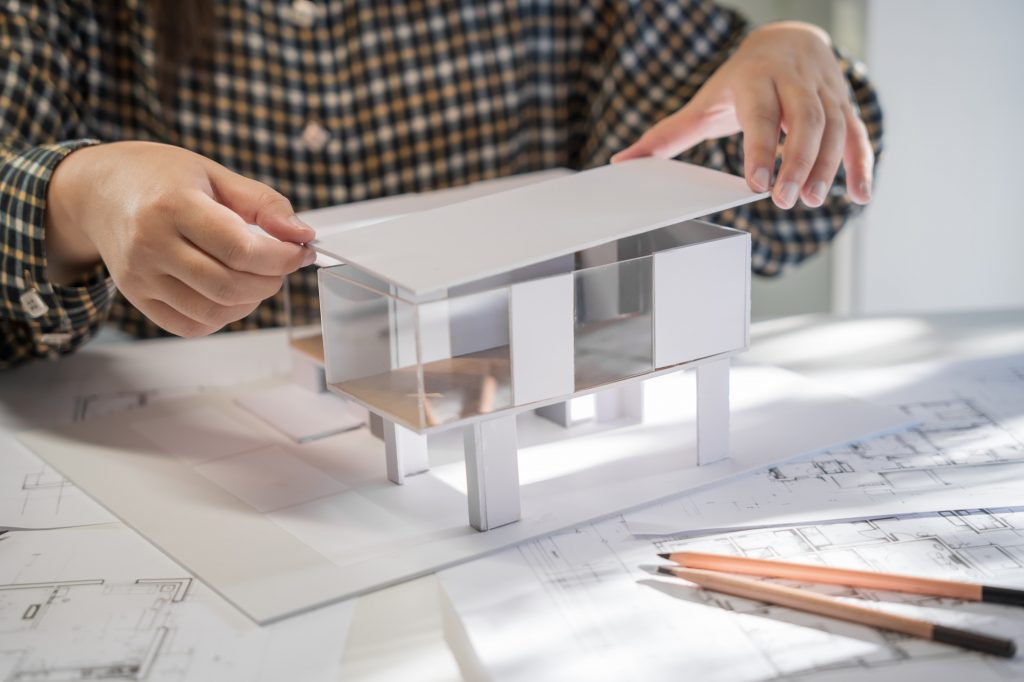 Architektin bei der Arbeit an einem Gebäudemodell – Planung eines modernen Gewerbe- und Wohngebäudes des Bauunternehmens Bölts.