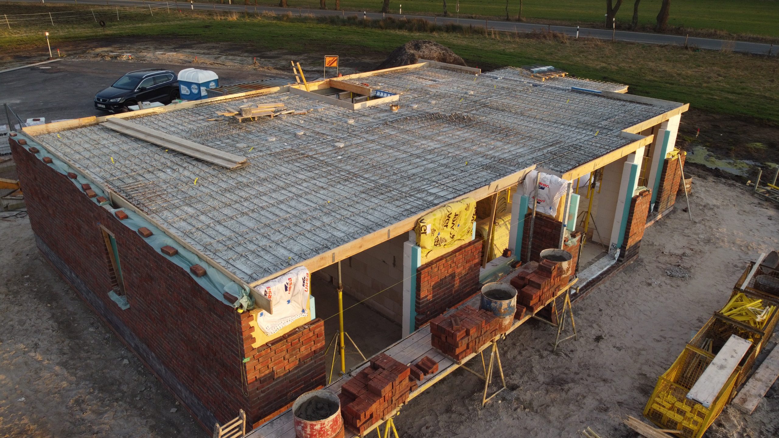 Bauphase eines Einfamilienhauses mit gemauerter Fassade und vorbereiteter Betondecke – Projekt des Bauunternehmens Bölts.